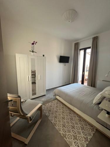 a bedroom with a large bed and a chair at Suite con jacuzzi in pieno centro in Benevento