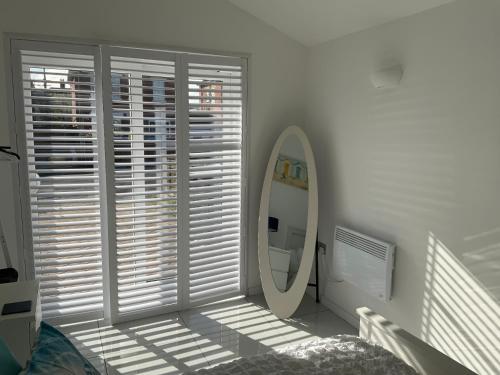 a mirror in a white room with a window at Double Bedroom with Private Entrance in Weymouth
