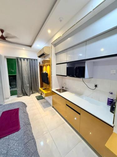 a large kitchen with white cabinets and a sink at Aayu's Home 74 in Noida