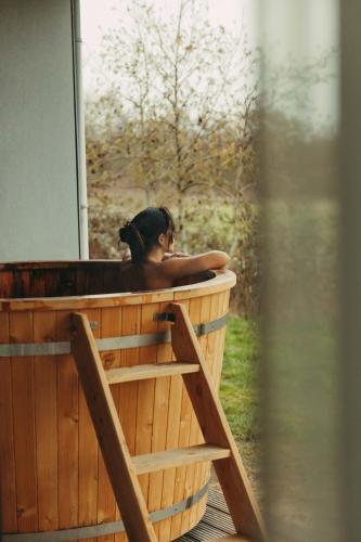 a woman is sitting in a hot tub at Garden Suites with Private Hottub - Duinhotel in Burgh-Haamstede zeeland in Burgh Haamstede