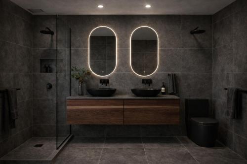 a bathroom with two sinks and two mirrors at Voltage Lodge Collie in Collie