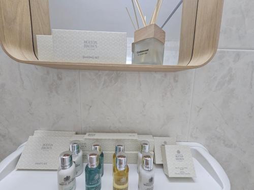 a bathroom sink with several bottles ofodorizers on it at Beach Front View Apartment Sea Pool & Prime Location in Limassol