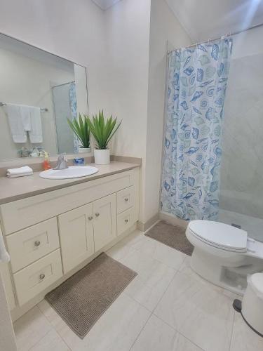 a bathroom with a toilet and a sink and a shower at 102 Lighthouse Bay Barbados in Christ Church