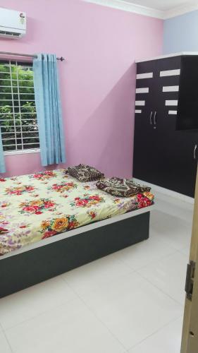 a bedroom with a bed with a floral blanket at Avani homestay in Subrahmanya