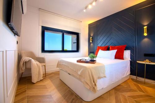 a bedroom with a large white bed with red pillows at panoramic boutique con preciosas vistas in Benalmádena