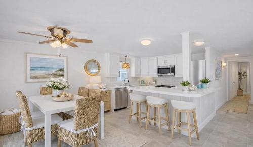 a white kitchen with a table and some chairs at Mermaid Manor in Brighton Beach