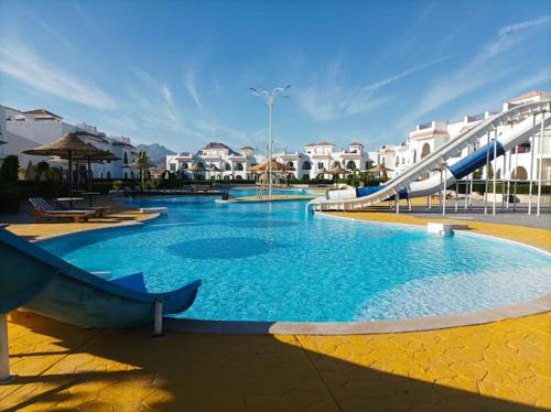 a large swimming pool with a slide in a resort at Jemmy Home in Sharm El Sheikh
