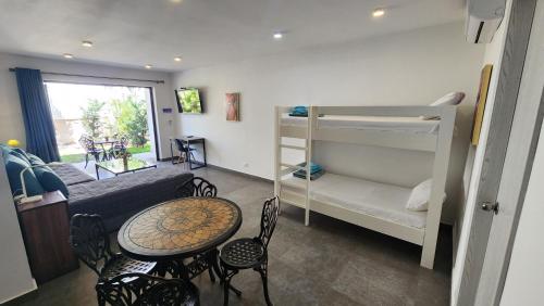 ein Wohnzimmer mit einem Bett, einem Tisch und einem Etagenbett in der Unterkunft Hotel Oasis-Dream Holidays - La Petite France in San Bernardino