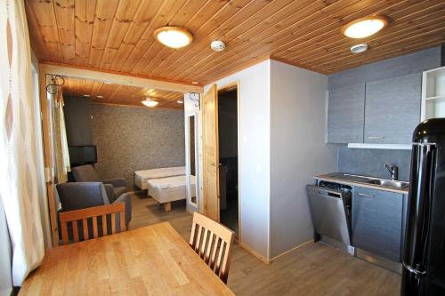 a kitchen with a table and a room with a bed at Kelkkakoivu in Jämsä