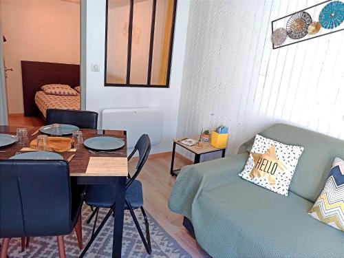 a living room with a table and a couch at Les Apparts du Vignal de Cheyrac in Polignac