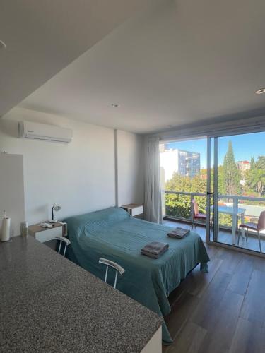 a bedroom with a bed and a balcony with a view at La Raquel in La Plata