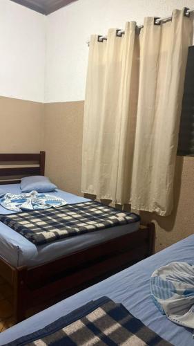 a bedroom with two beds and a window at HOTELSÃORAFAEl in Água Boa