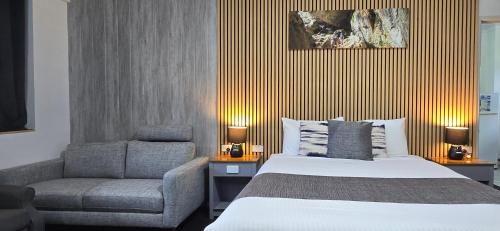 a bedroom with a bed and a chair at Archer Park Motel in Rockhampton