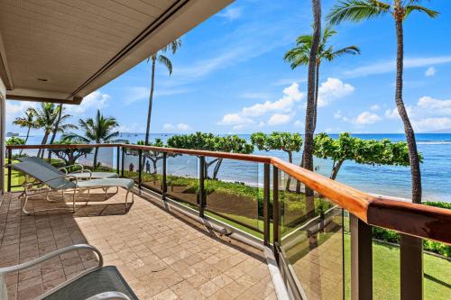 a balcony with chairs and a view of the ocean at Puunoa Beach Estates 205 in Lahaina