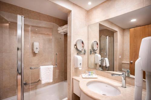 a bathroom with a sink and a shower at Lavi Kibbutz Hotel in Lavi