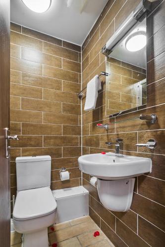 a bathroom with a toilet and a sink at Lucky 8 Hotel in Ilford
