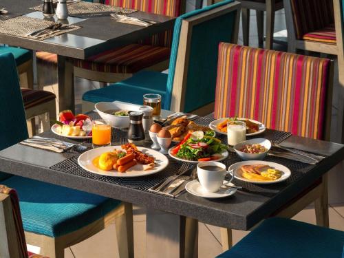 a breakfast table with plates of food on it at Mercure Pattaya Ocean Resort in Pattaya