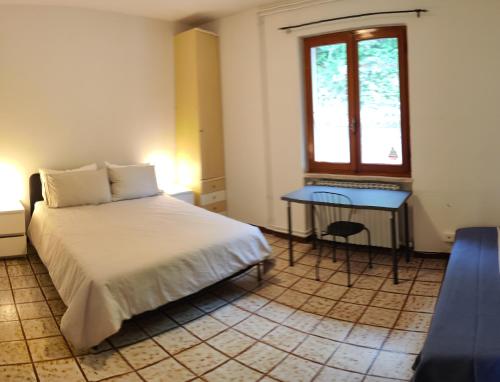a bedroom with a bed and a table and a window at Peaceful Lakefront in Marone