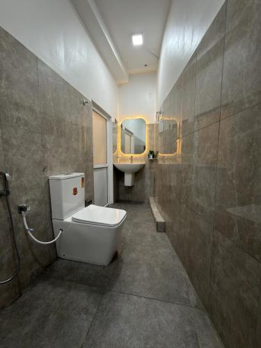 a bathroom with a toilet and a sink and a mirror at Flower Resort Ella in Ella