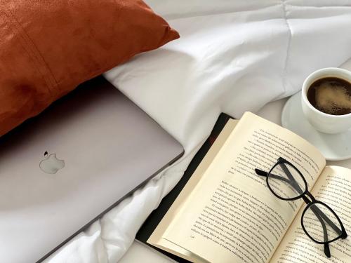 an open book and a cup of coffee next to a laptop at Canaryislandshost l Balcón del Mar in Puerto del Carmen