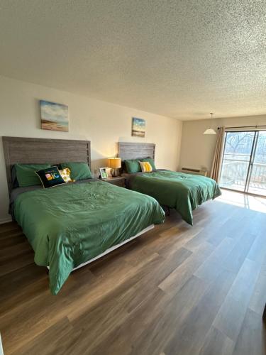 two beds in a bedroom with green sheets at Margarita Manor on Staniel Cay in Osage Beach