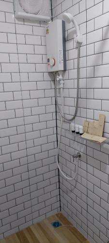 a bathroom with a white tiled wall at วันรีสอร์ท in Ratchaburi