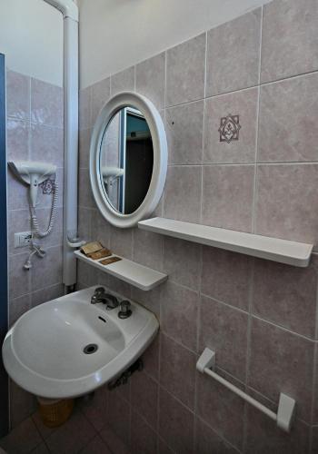 a bathroom with a sink and a mirror at Hotel Biagini in Rimini