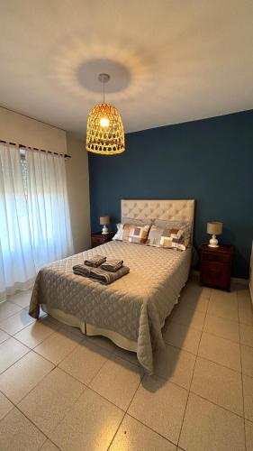 a bedroom with a large bed with a blue wall at La casita in Río Cuarto