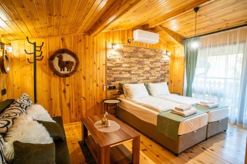 a bedroom with a bed in a room with wooden walls at Green View 2 in Skrino