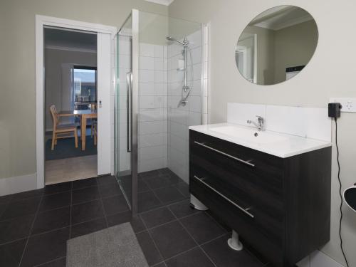 a bathroom with a sink and a shower and a mirror at The French River Chalets in Kalgan