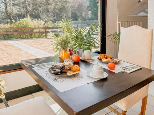 ein Tisch mit einem Tablett mit Frühstücksspeisen darauf in der Unterkunft Garden & City Capvern-les-Bains in Capvern