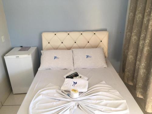 a bed with white sheets and towels on it at Paulos Pousada in Lagoa Santa