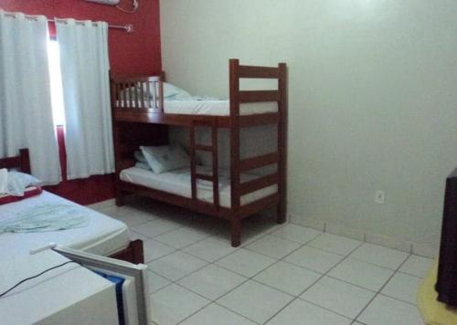 a room with a bunk bed and a table with a chair at Paulos Pousada in Lagoa Santa