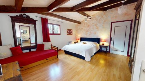a bedroom with a bed and a red couch at Le Clos des Dryades climatisé s in Vers