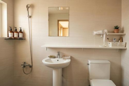 a bathroom with a sink and a toilet and a mirror at Ara Guesthouse in Busan