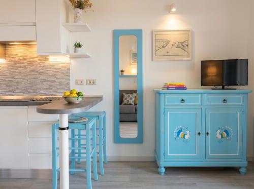 a kitchen with a blue cabinet and a table at Stintino Apartments in Stintino