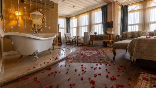 ein Badezimmer mit Badewanne und roten Blumen auf dem Boden in der Unterkunft Kitapevi Hotel in Bursa