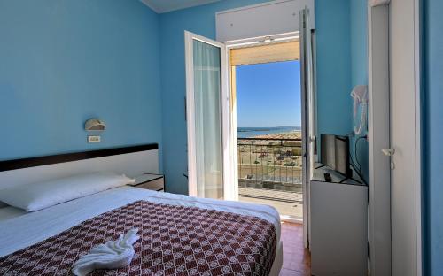 a bedroom with a bed and a sliding glass door at Hotel Biagini in Rimini