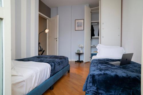 a bedroom with two beds and a laptop on a desk at Corte Cavour Duplex Gallarate centro, Wifi e Garage in Gallarate