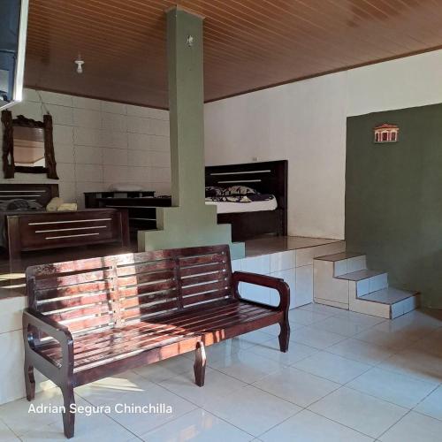 a wooden bench in a room with a fireplace at Cabinas Chinchilla in Quepos