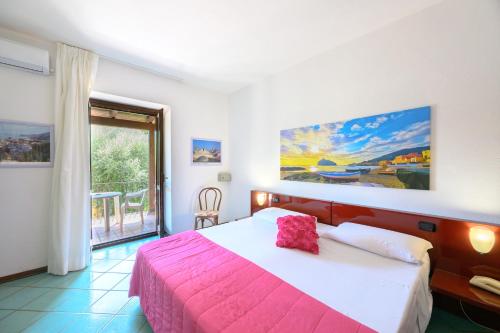 a bedroom with a large bed with a pink blanket at Hotel Annabelle in Ischia Town