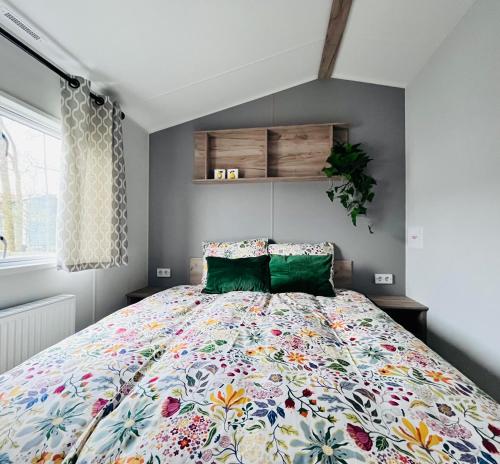 a bedroom with a large bed with a colorful bedspread at B&B Voor De Zee in Westerland