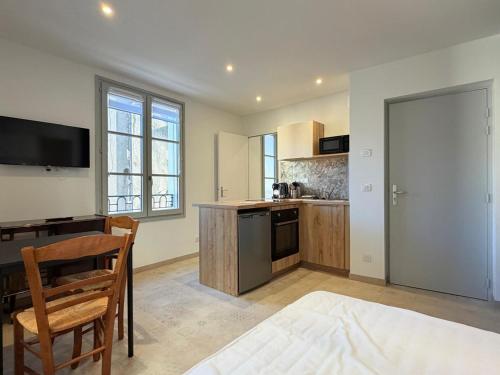 a kitchen with a table and a dining room at Les Suites Villeneuve - 2 in Le Puy-en-Velay