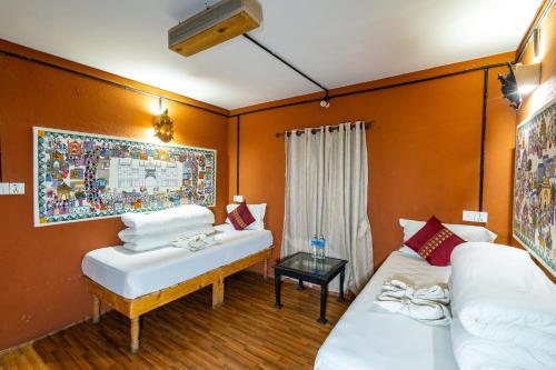 two beds in a room with orange walls at Trekking Lodge Nepal in Kathmandu