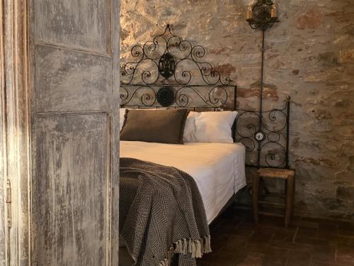 ein Schlafzimmer mit einem Bett mit schmiedeeisernem Kopfteil in der Unterkunft Loft in Begur
