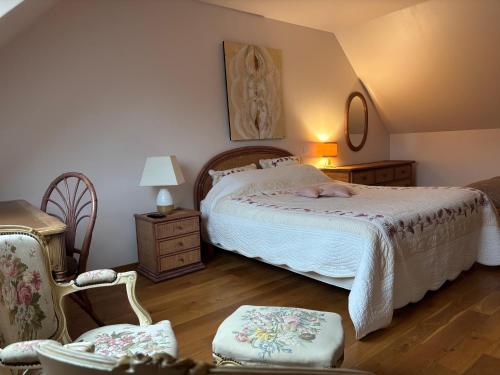 a bedroom with a bed and a chair at Relais du Chat Prosper in Lescherolles
