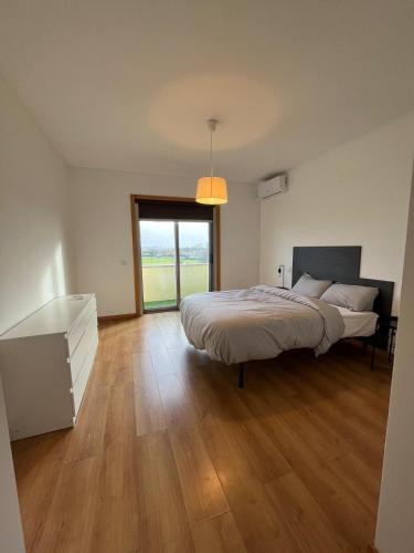 a bedroom with a bed and a large window at Alojamento Local Pando in Aveleda