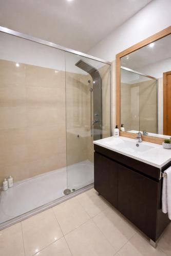a bathroom with a tub and a sink and a shower at Alojamento Local Pando in Aveleda