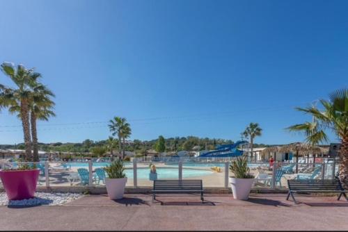 a group of benches sitting next to a swimming pool at Mobilhome Luminosa*** in Fréjus