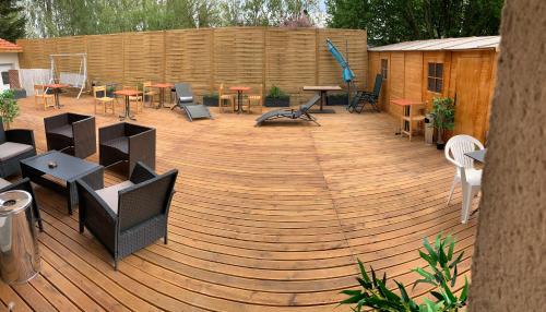 a wooden deck with tables and chairs on it at STUDIO Confort Clim 20min Orly-45min Paris Disney in Corbeil-Essonnes